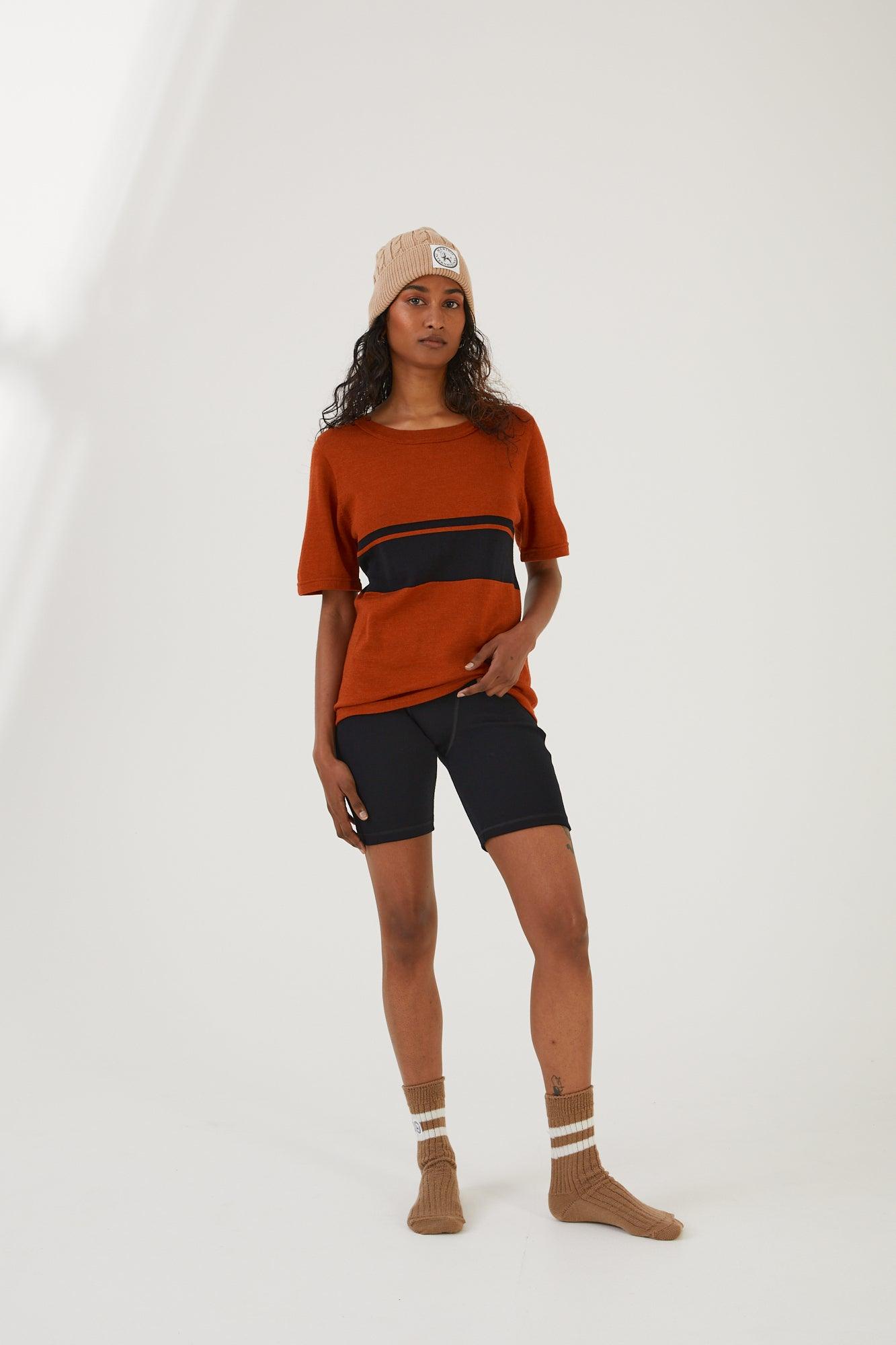 A person wearing merino wool socks, merino wool biker shorts, a merino wool t-shirt and a merino wool beanie