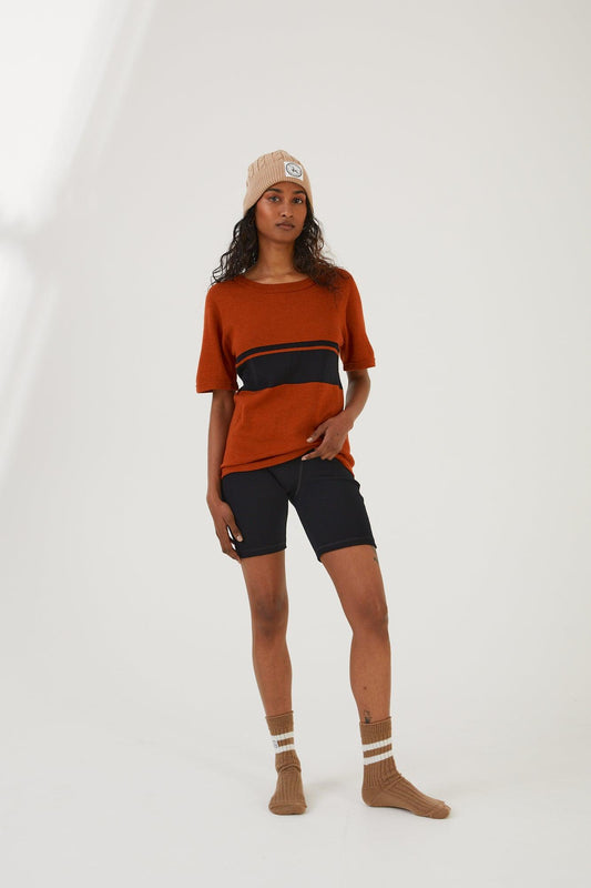 A person wearing merino wool socks, merino wool biker shorts, a merino wool t-shirt and a merino wool beanie