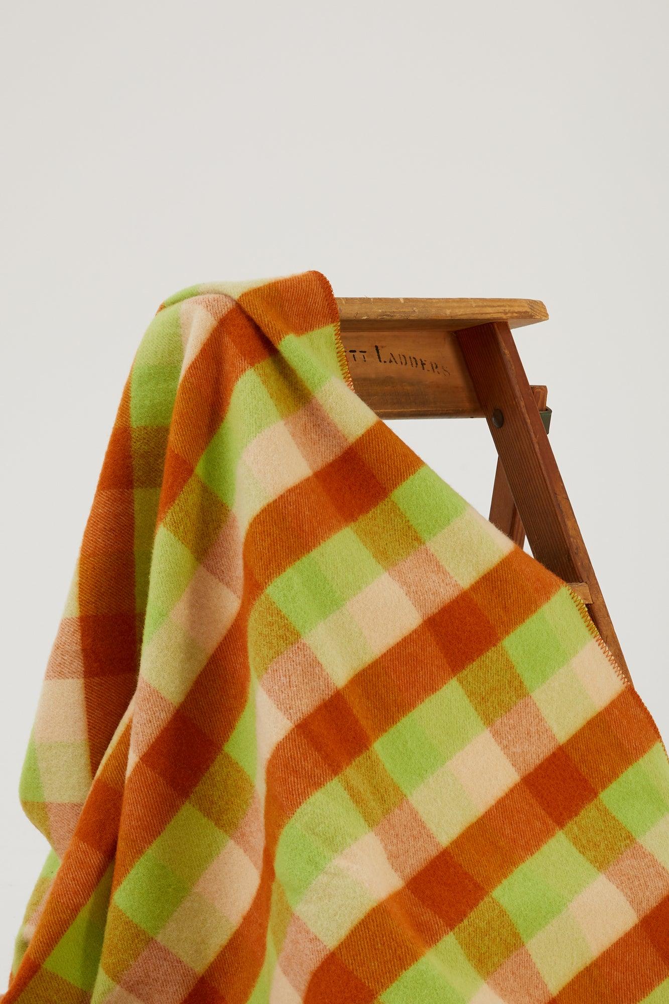 Close up of a wool blanket draped over a wooden step ladder