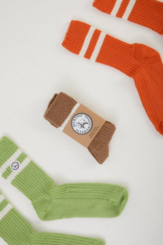 3 pairs of merino wool socks, 1 folded in it's package and the other two laid out flat