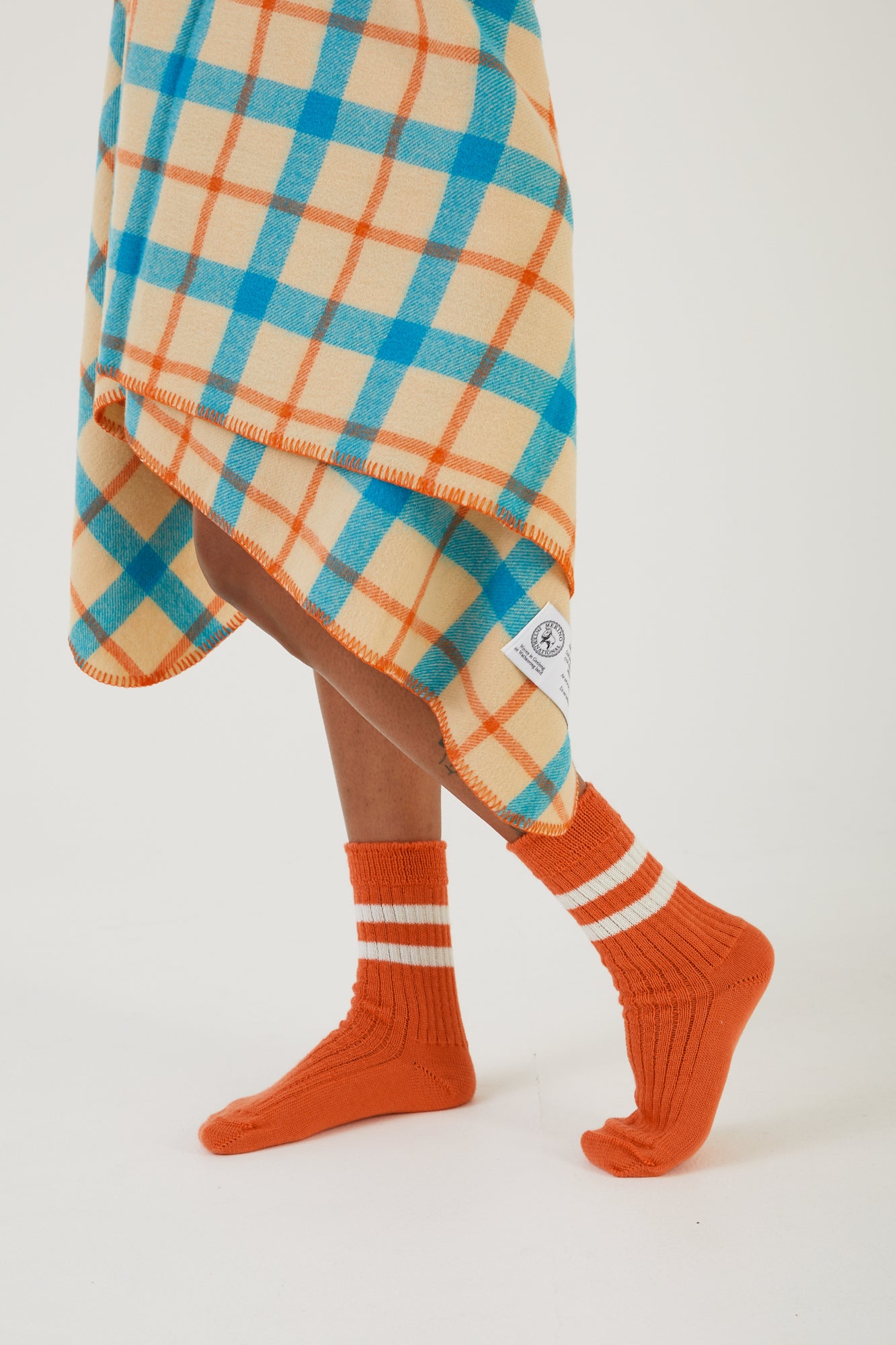 A person with a wool blanket wrapped around their waist wearing merino wool socks