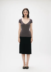 Woman wearing a gray top and black skirt on a white background