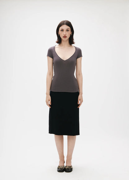 Woman wearing a gray top and black skirt on a white background