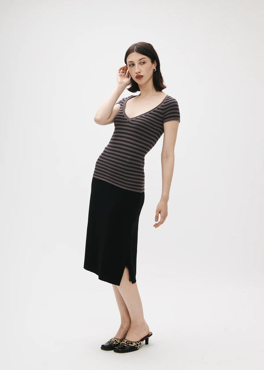 Woman wearing a striped top and black skirt on a white background