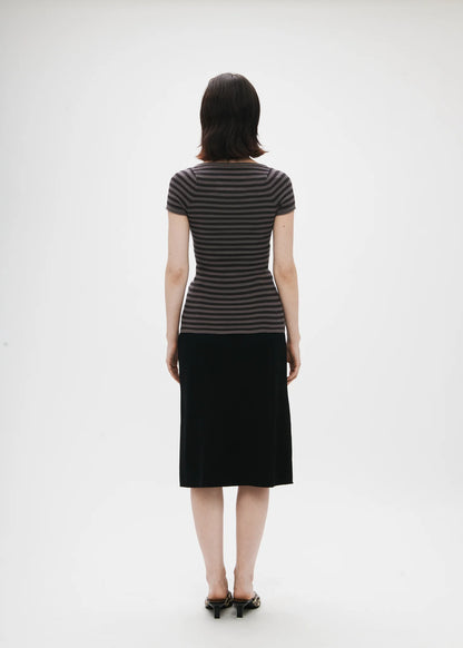 Person wearing a black and gray striped dress on a white background