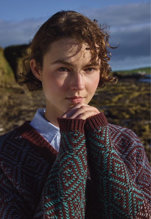 Person wearing a patterned sweater in a natural setting