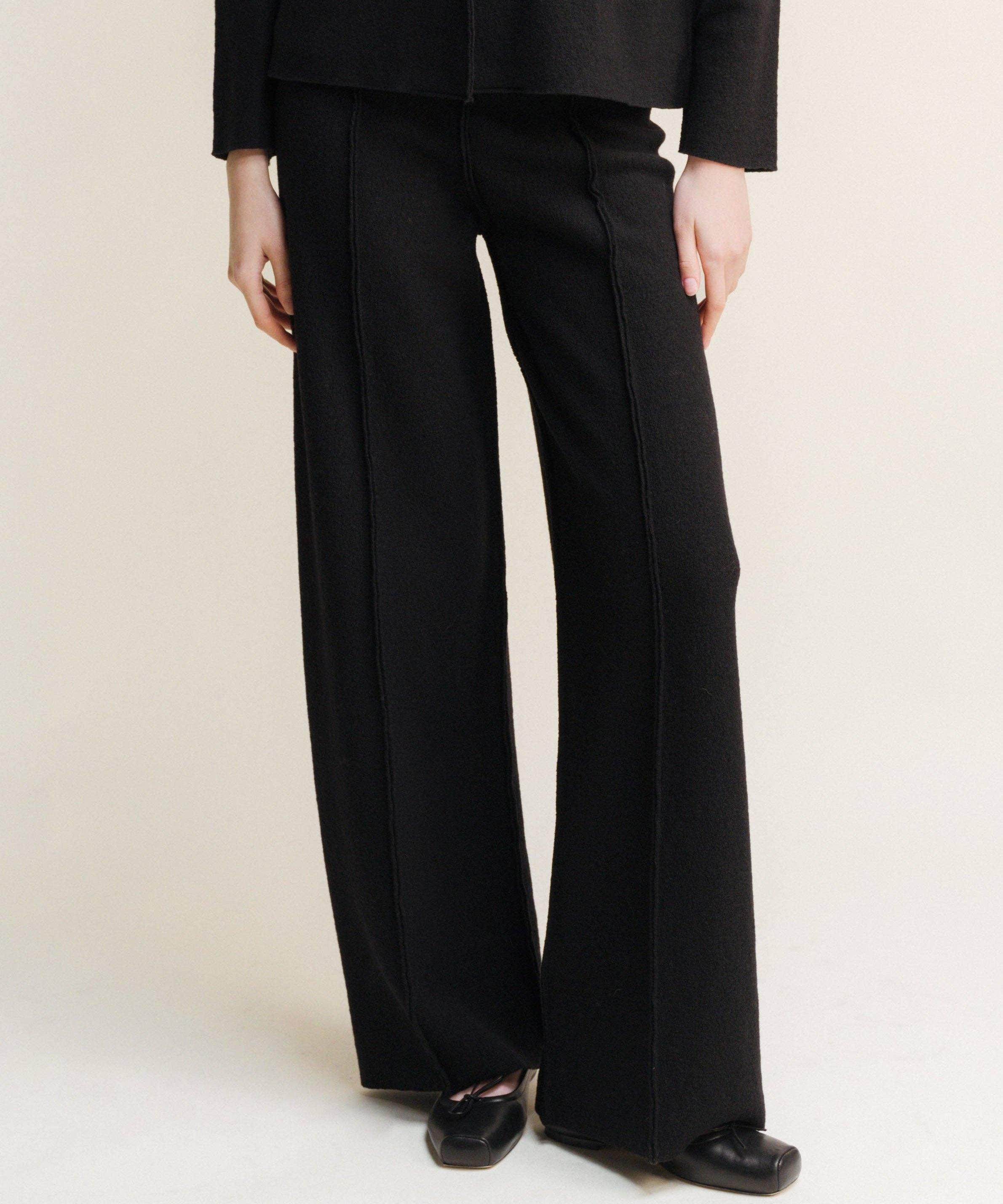 black boiled wool bootleg cut trousers with exposed seam detail down the front of both legs. 