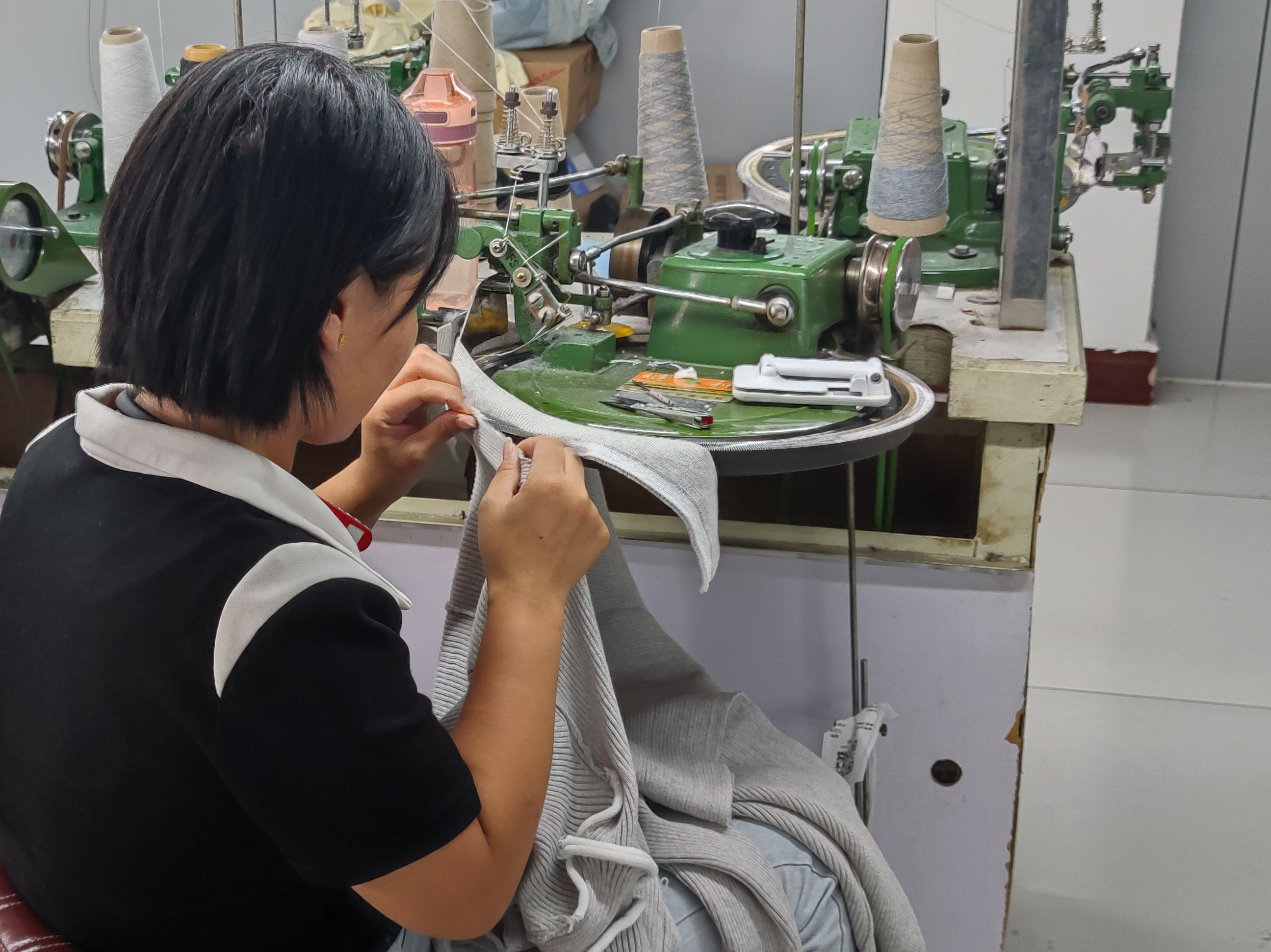 Person working at a linking machine in a factory setting