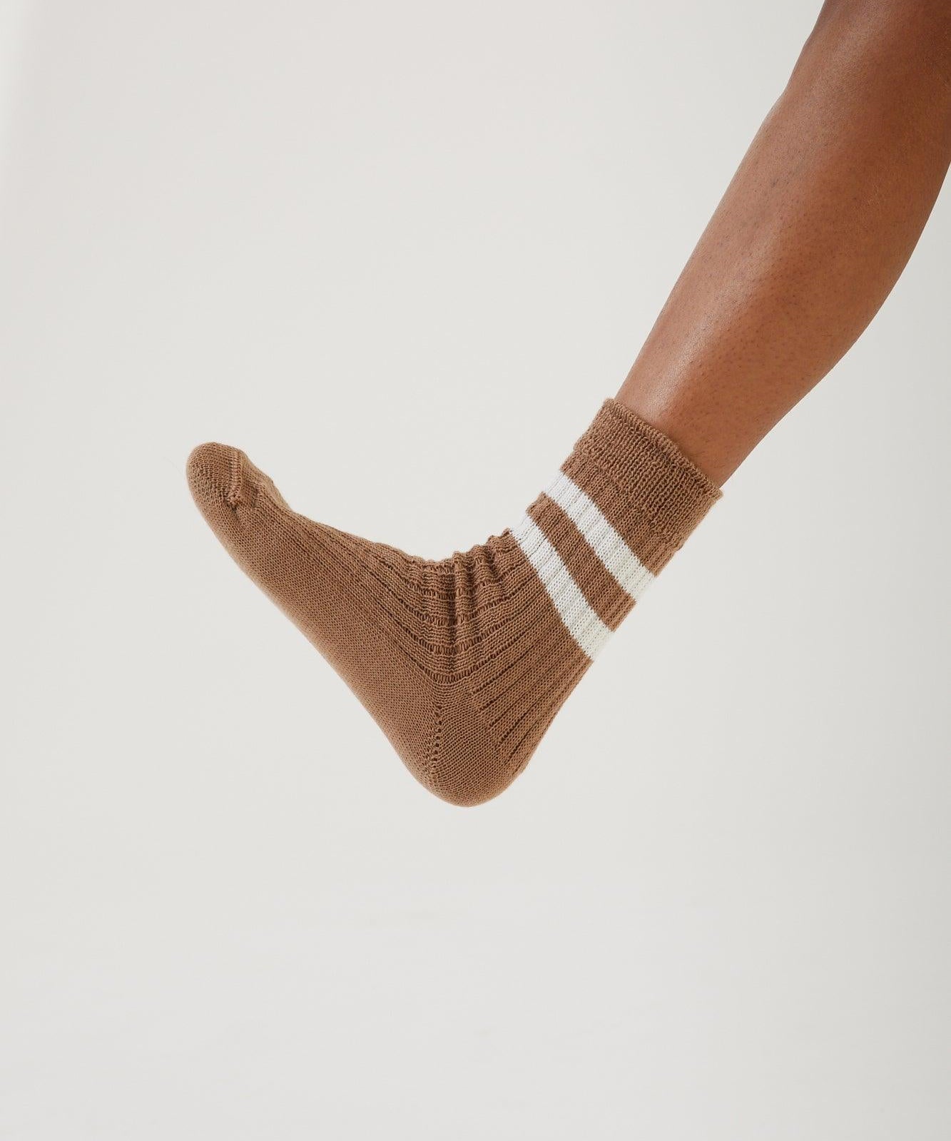A foot hovering wearing a merino wool sock