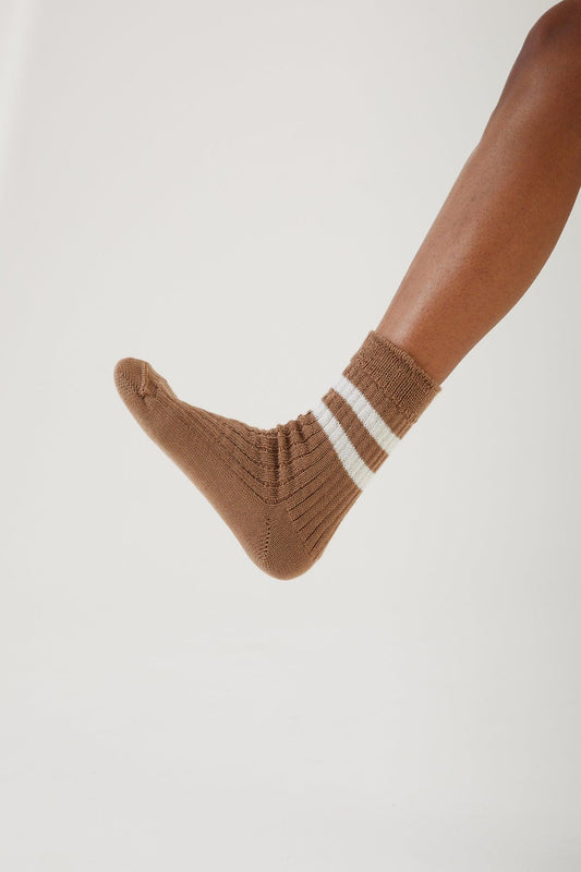 A foot hovering wearing a merino wool sock