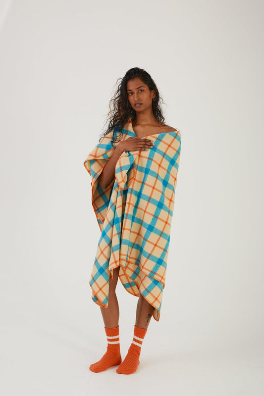 A person wearing merino wool socks with a wool bed throw wrapped around their body 