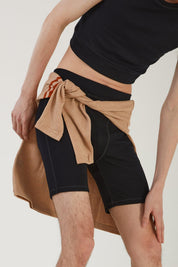Close up of a person wearing merino wool bike shorts and a merino wool tank with a merino wool jumper tied around their waist