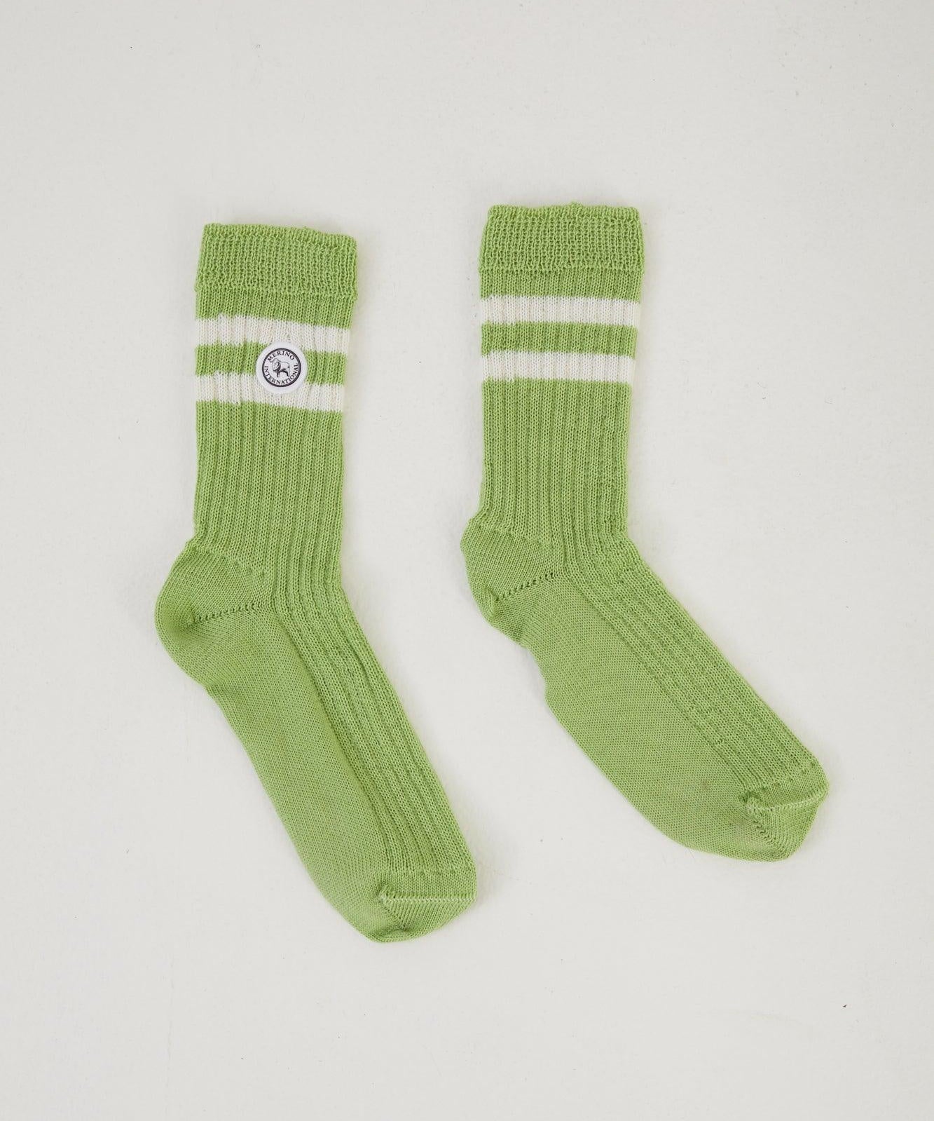 Flat lay of green merino wool socks with a retro double stripe