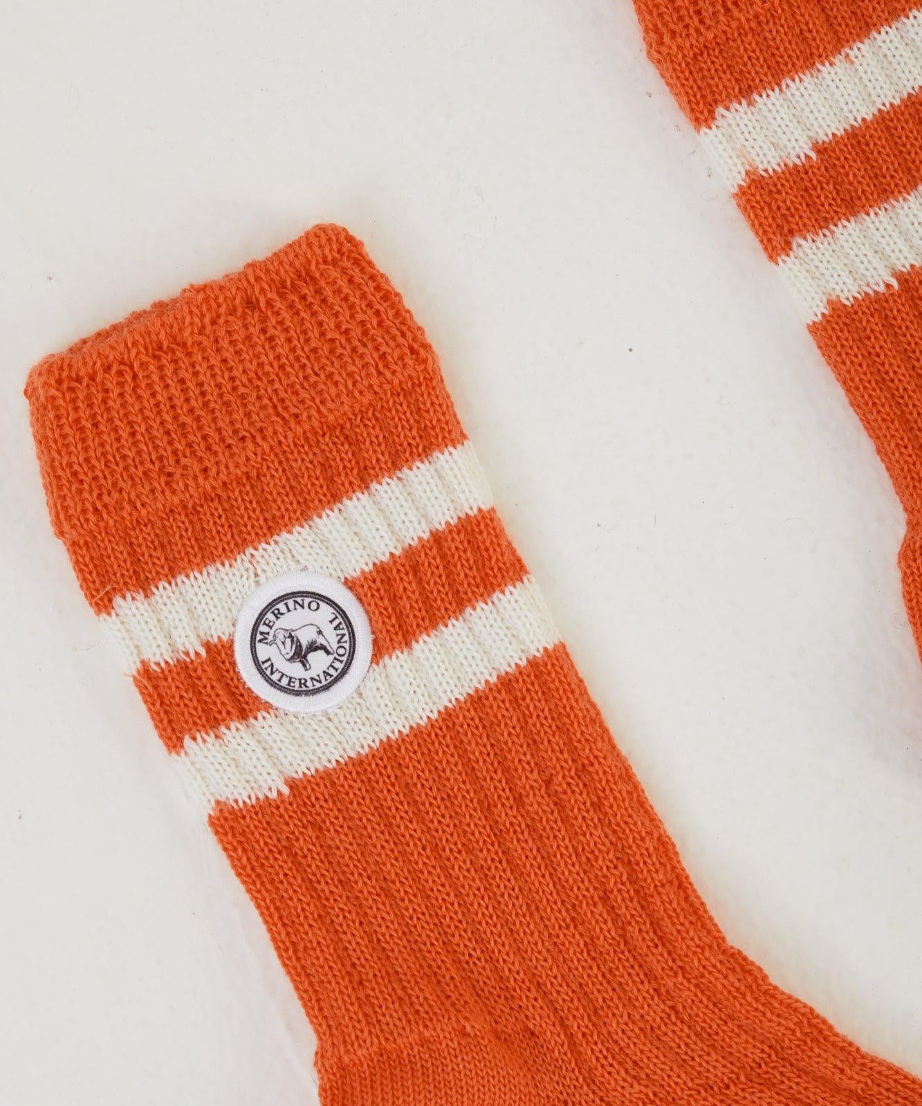 Zoomed in image of rust coloured merino wool socks laid out flat